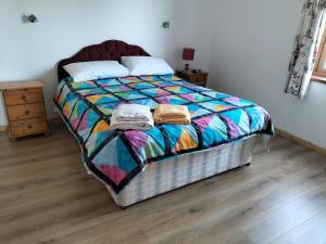 BallymotePeace and Tranquility的一间卧室配有一张带五颜六色棉被的床