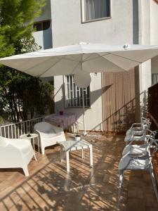 莱西纳Villa Italia - Marina di Lesina的庭院配有白色遮阳伞和桌椅