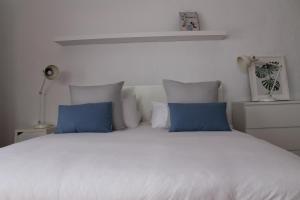Valles de OrtegaCasa Volcan De Gayria的一间卧室配有白色床和蓝色枕头