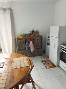 帕皮提BUNGALOW PAMATAI的厨房配有木桌和冰箱。