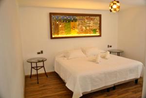 San CarlosHotel Boutique Casona Violeta的卧室配有白色的床和2张桌子