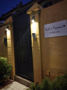 马拉加Dudi's Peppers的房屋边的标志,有黑色的门