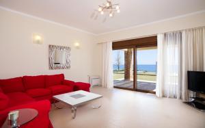 吉奥塔略Private beach villa Princess的客厅配有红色沙发,享有海景
