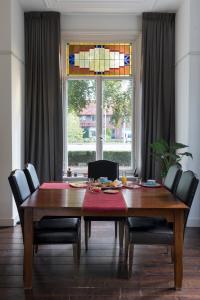 LentB&B Villa Kriekenbeek的餐桌、椅子和彩色玻璃窗