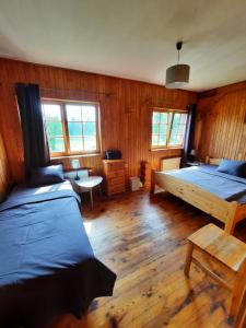 Rauna约恩 - 伊艾维纳斯旅馆的一间卧室设有两张床,铺有木地板