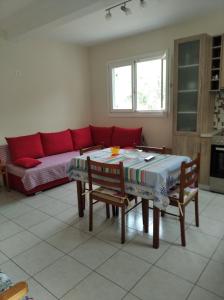 卡拉内拉ASTERIA HOUSE的客厅配有桌子和红色沙发