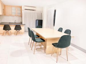 曼谷格兰德豪华公寓的厨房配有木桌和椅子
