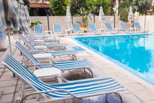 拉纳卡圣雷莫酒店 的游泳池旁的一排躺椅