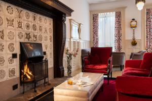楚奥茨恩吉迪纳酒店的客厅设有壁炉和红色椅子