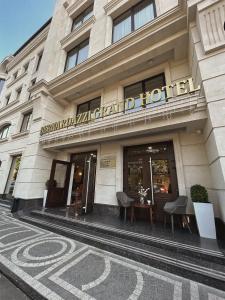 基希讷乌Bernardazzi Grand Hotel的酒店大楼前面设有桌子