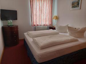 弗赖辛鲁汶小酒馆酒店的酒店客房,配有床和电视