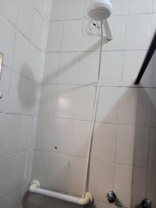伊利亚孔普里达Temporada no Paraíso的浴室设有白色瓷砖墙和淋浴。