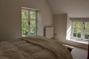 BrockleyCharacterful Cottage adjacent to an Orchard的一间白色卧室,配有床和2个窗户