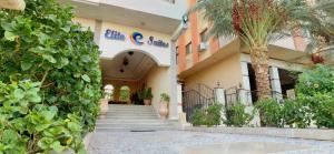 赫尔格达Elite Suites Hurghada的一座有楼梯的建筑,前面有棕榈树