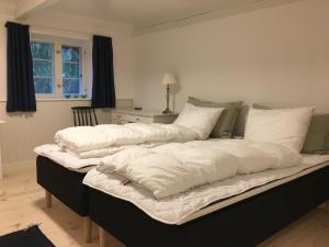 莱斯Tanggården Skoven的一张配有白色床单和枕头的大床
