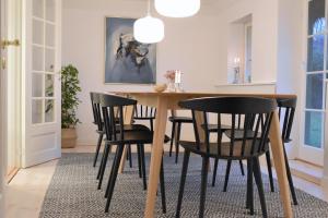 莱斯Tanggården Skoven的用餐室配有木桌和黑椅子