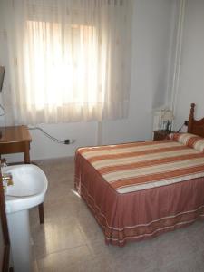 马德里洛斯安第斯旅馆的一间卧室配有床、水槽和窗户