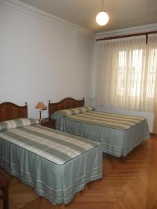 马德里洛斯安第斯旅馆的铺有木地板的客房内的两张床