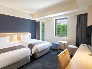府中市Hotel Keyaki Gate Tokyo Fuchu的酒店客房设有两张床和窗户。