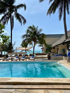 帕杰Paje Beach Apartments & Hotel的一座棕榈树和海洋游泳池
