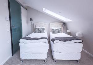 斯德哥尔摩霍特哥特酒店的配有白色墙壁的小客房内的两张床