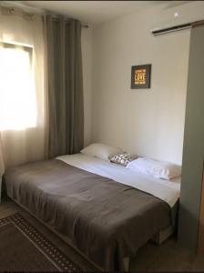 贝西奇Candy apartment central location Bečići的卧室内的一张床铺,墙上挂着一个时钟