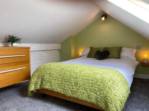 兰迪德诺'Llandudno Central' - 2 Bed Luxury Flat, Close to Town and Beaches的一间卧室配有一张带绿色墙壁的床