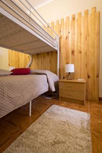 贝雅贝雅旅舍的一间卧室设有一张床和木墙