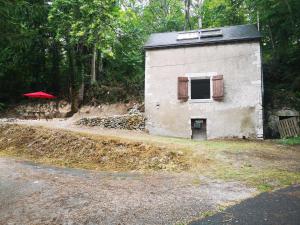 圣热尔韦拉福雷chez Pauline & Sébastien le Bien-être proche de la forêt的一座小建筑,设有窗户和红伞
