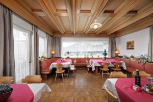 Auna di SopraGasthof Mesnerwirt的餐厅设有桌椅和大窗户。