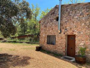 San Pablo de los MontesEl Refugio de San Pablo de los Montes的一座石头建筑,有门,旁边还有植物