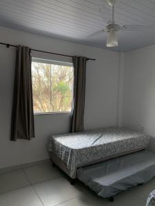 弗洛里亚诺波利斯Casa temporada的一间卧室设有一张床和一个窗口