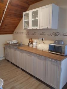 凯斯特海伊Toldi Apartman的厨房配有白色橱柜和木制台面