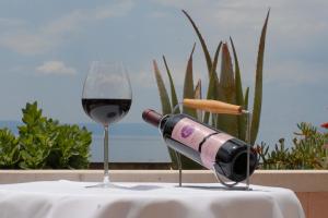 马卡尔斯卡罗西娜酒店的坐在玻璃旁边的桌子上,一瓶葡萄酒