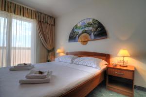 马卡尔斯卡罗西娜酒店的一间卧室设有一张大床和一个窗户。
