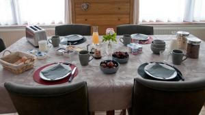 滑铁卢Wellintown Guest House的餐桌、白色桌布和椅子