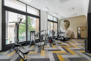 布达佩斯Emerald Downtown Luxury Suites with Hotel services的健身房设有跑步机和位于后面的雕像