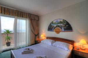 马卡尔斯卡罗西娜酒店的一间卧室设有一张大床和一个大窗户