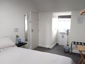 莱斯特Comfort Guest House的卧室配有白色的床和水槽