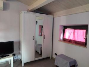 佩斯卡拉Residenza Flores的一间设有镜子的橱柜和电视的房间