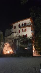 加尔达湖滨La Berlera - Riva del Garda的一座古老的建筑,晚上有红色的门窗