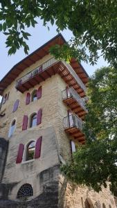 加尔达湖滨La Berlera - Riva del Garda的一座高大的建筑,设有紫色窗户和阳台