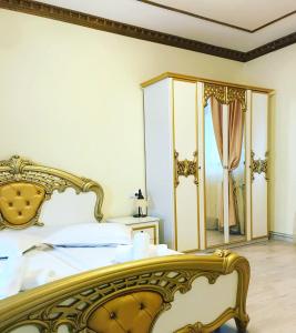 锡比乌红衣主教裴森酒店的一间带金色床和镜子的卧室