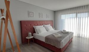 科维良Villa Regadio的一间卧室配有一张大床和红色床头板
