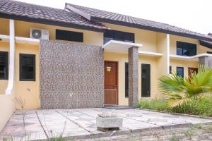 KebintiOYO 3438 Pasir Padi Inn Syariah的黄色的房子,有门和庭院