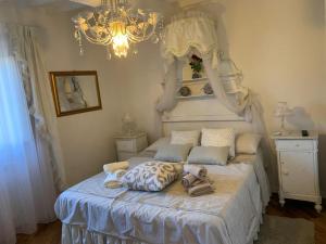 阿雷佐Appartamento incantevole nel centro di Arezzo的卧室配有带枕头和吊灯的白色床。