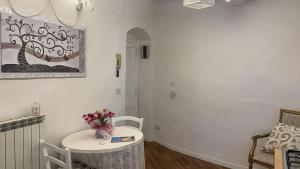 阿雷佐Appartamento incantevole nel centro di Arezzo的白色的房间,配有一张桌子和花瓶