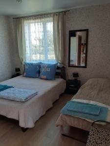卡罗利诺-布加兹Гостевой дом Уют的一间卧室配有两张带蓝色枕头的床和窗户。