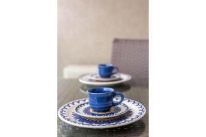 马卡埃Flat 1506 - Studio duplo em Macaé的桌子上两个蓝色的杯子和碟子