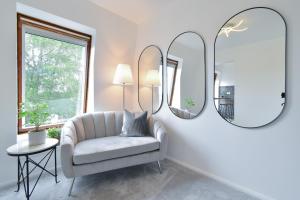 卡特顿Stylish One Bed Apartment Near Cotswolds RAF的客厅配有椅子和两面镜子